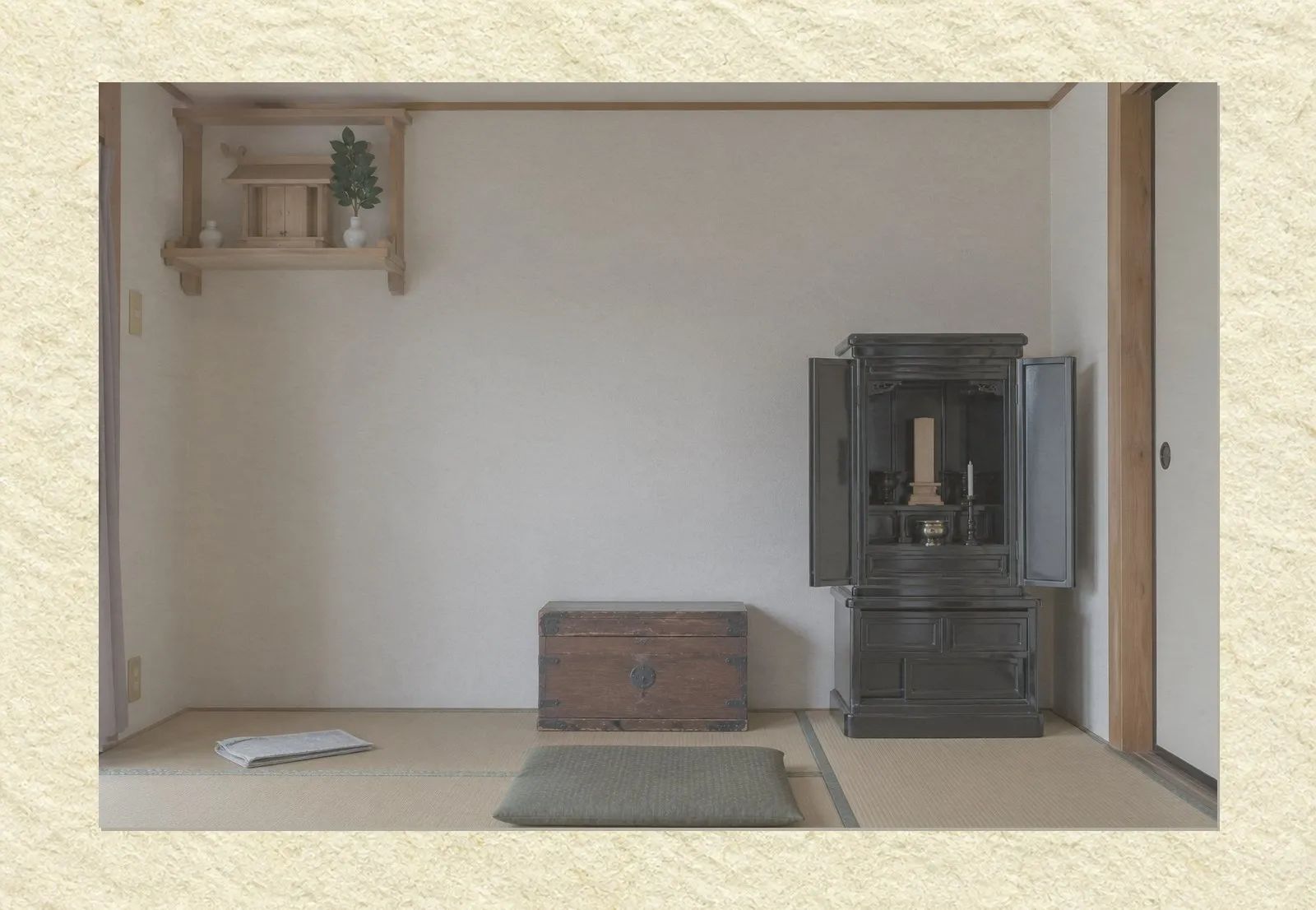 An empty Japanese living room seen straight on. A small wooden Shinto shelf holding a miniature shrine and two white vessels is mounted high on the left wall. A dark lacquered Buddhist household altar with its doors open stands against the right wall. A low wooden chest sits between them on the tatami floor, with a folded newspaper and a cushion nearby. No people are present.